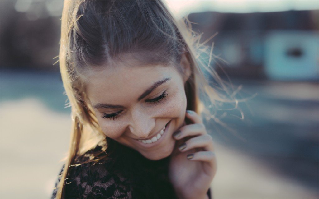 A girl smiling and looking away from the camera, enjoying the moment.