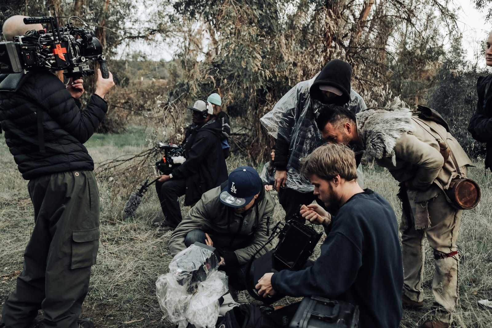 Actors in costume checking footage on the set of 'Dark Arrows' feature film, symbolizing character development and storytelling in writing.